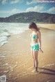 A woman in a bikini standing on a beach.