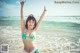 A woman in a bikini standing on the beach.