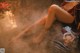 A woman is sitting in a hot tub with steam coming out of her feet.