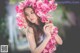 A woman in a blue dress holding a bunch of pink flowers.