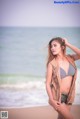 A woman in a bikini standing on a beach.