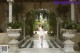 A woman in a white dress standing in a courtyard.