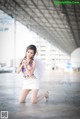 A woman in a white dress with angel wings posing for a picture.