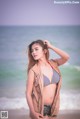 A woman in a bikini standing on a beach.