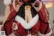 a woman in a santa claus outfit holding a bell