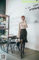 A woman standing in front of a table in a room.