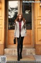 A woman standing in front of a wooden door.