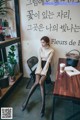 A woman sitting at a table with a cup of coffee.