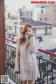 A woman standing on a balcony talking on a cell phone.