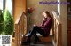 A woman sitting on the stairs of a building.