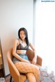 A woman sitting in a chair wearing fishnet stockings.