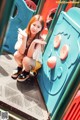 A young woman sitting on a playground slide.