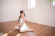 A young ballerina sitting on the floor in a room.