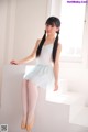 A young ballerina is sitting on the steps of a building.