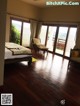 A bedroom with a large bed and wooden floors.