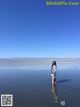 A woman standing in the middle of a body of water.