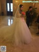 A woman in a wedding dress holding a bouquet of flowers.