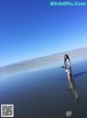 A woman standing in the middle of a body of water.