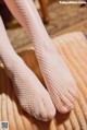 A close up of a woman's feet in fishnet stockings.