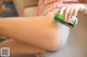 A woman sitting on a couch holding a can of beer.