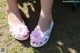 A pair of white sandals with pink flowers on them.