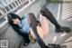 A woman in a school uniform is laying on the ground.