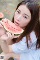 A young woman eating a slice of watermelon.