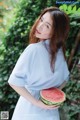 A woman holding a slice of watermelon in her hands.