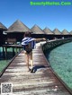 A woman in a bikini standing on a wooden pier.