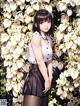 A woman standing in front of a bunch of white flowers.