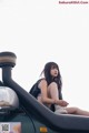 A woman sitting on top of a green car.